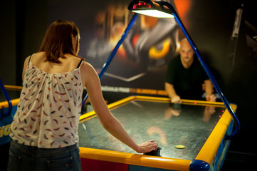 Young couple playing a game of air hockey