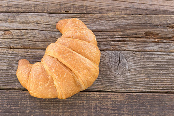 Croissant on wooden background