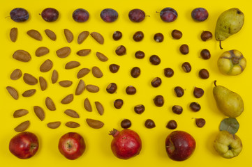Autumn setting of organic nuts and fruits on yellow background