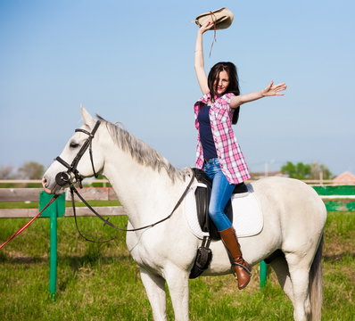 Woman sitting  horse. Day. Half height. Pink plaid shirt