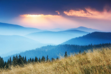 View of colorful sunrise in autumn mountains.