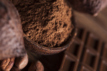 Chocolate bar, candy sweet, cacao beans and powder on wooden bac