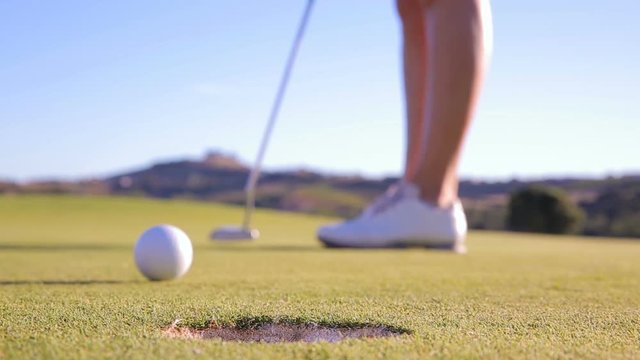 The golfer is trying to get the ball in the hole. Unsuccessful kick. Close Up