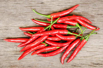 multitude of red chili peppers on wooden table, closeup view