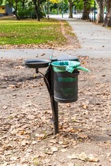 Metal trash can in the park in autumn