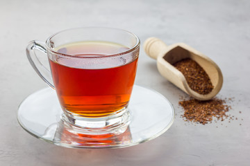 Cup of healthy herbal rooibos red tea in glass cup