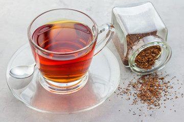 Cup of healthy herbal rooibos red tea in glass cup