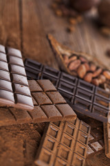 Dark homemade chocolate bars and cocoa pod on wooden