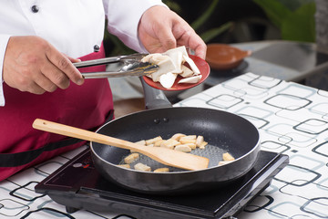 Chef putting eringi for cooking