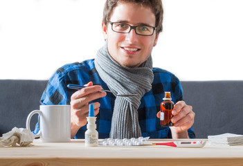 Erkälteter junger Mann mit Hustensaft