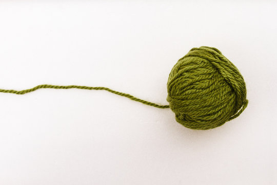 Green ball of wool on white background
