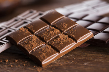 Dark homemade chocolate bars and cocoa pod on wooden