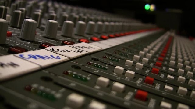 A close up shot of a mixing board in a recording studio with illuminating LED lights. HD 1080.