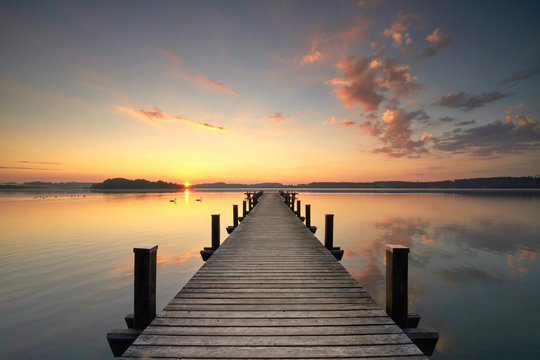 Fototapeta ciepłe jesienne światło na jeziorze, rano na molo