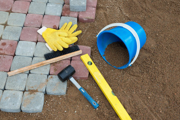 Stone blocks rubber hammer level gloves and tape measure