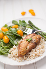 Dinner plate of lemon pepper mustard chicken with brown rice, Italian garden salad, and asparagus cooked in avocado oil on white