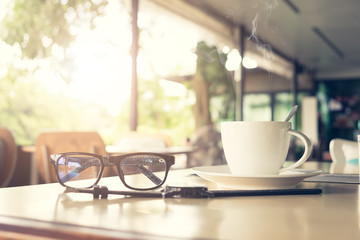 Sunrise Monring with hand holding a coffee cup with red cake at coffee shop