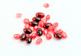 omega 3 capsules and pomegranate fruit on the white background.health concept