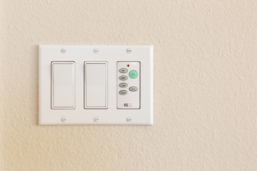 Light Switches and Fan Control on Wall of Home.