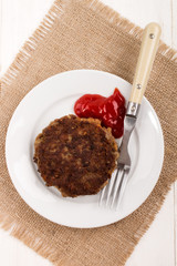 fried rissole on a plate with ketchup