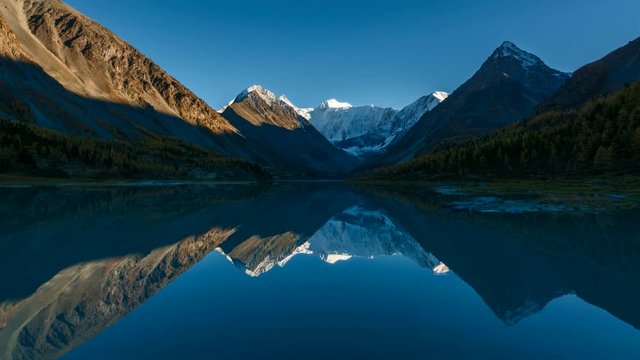 Time Lapse. The Mountain Belukha in the reflection Akkem lake at sunset. Altai Mountains, Russia.