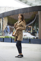 Portrait of a young beautiful woman in beige coat