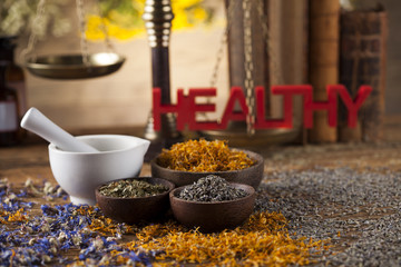 Healthy herbs on wooden table, mortar and herbal medicine