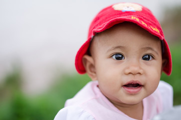 Cute little baby girl with red hat on nature background