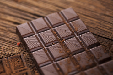 Dark homemade chocolate bars and cocoa pod on wooden