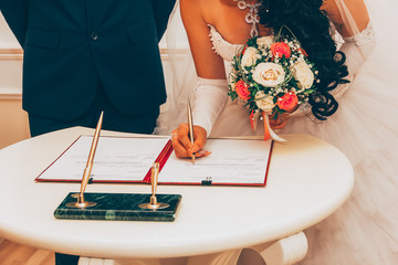 Wedding. Registration Of Marriage, The Bride With A Bouquet Of Flowers Signed A Marriage Contract A...