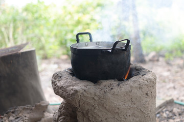 Pot water on the fire, tourists kettle on hot campfire. Camping