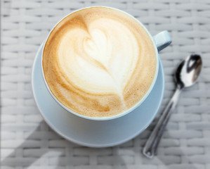 Delicious cappuccino coffee cup with froth heart design
