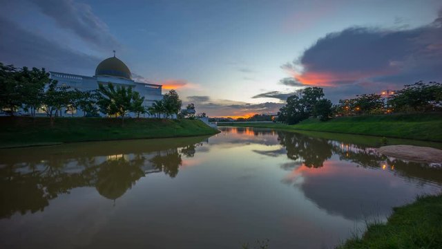 Majestic sunset sky over a mosque by the lake with perfect reflection. Time lapse. 