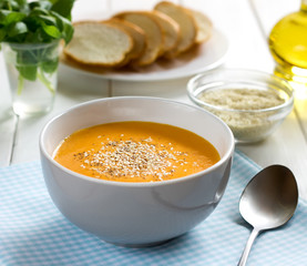 Pumpkin soup-puree with sesame in bowl on a blue napkin.