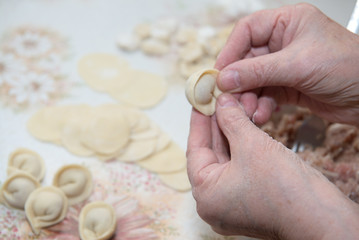 Homemade hand made traditional Russian pelmeni on the kitchen ta