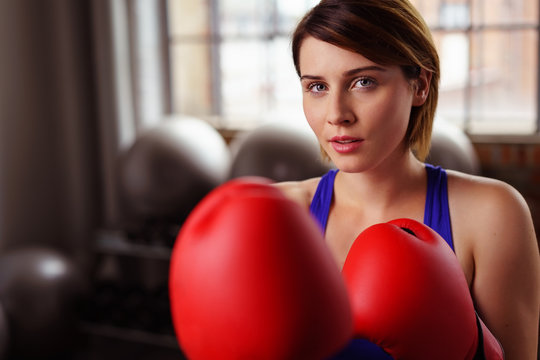 frau mit roten boxhandschuhen im fitness-club
