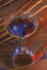 A reflection of the American flag in a glass of wine.