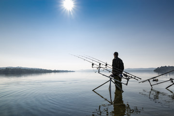 Fishing adventures. Fisherman near the carpfishing equipment 