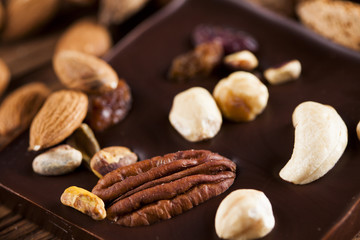Dark homemade chocolate bars and cocoa pod on wooden