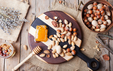 Assortment of nuts and honey Wooden cutting board