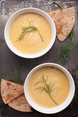 Fresh organic butternut squash fennel carrot soup with toasted whole wheat quesadillas on a metal background
