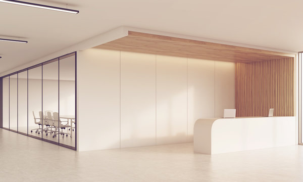 Side view of reception desk and meeting room in sunlit corridor