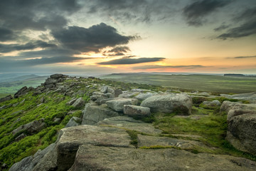 Sunset through clouds over rocky landscape
