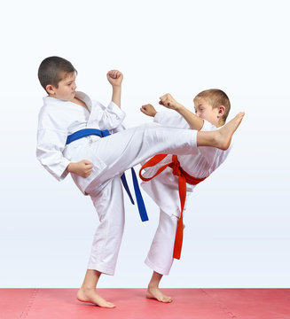Two karateka children are beating kick leg
