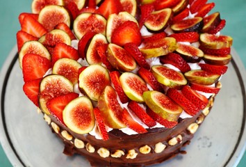 A vegan chocolate cake with fresh figs and strawberries