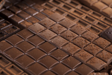 Dark homemade chocolate bars and cocoa pod on wooden