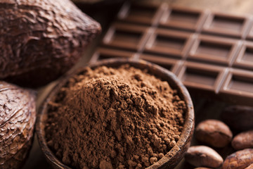 Chocolate bar, candy sweet, cacao beans and powder on wooden bac