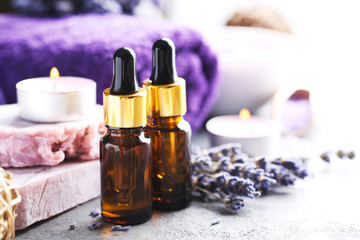 Obraz na płótnie Canvas Lavender oil with soap and flowers on grey table
