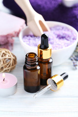 Lavender oil with soap and flowers on white wooden table