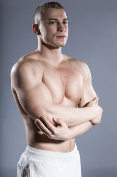 strong man bodybuilder with muscular body isolated on gray background